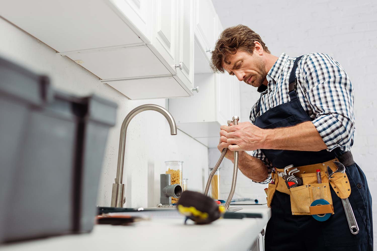 selective-focus-of-plumber-holding-metal-pipe-near-resize