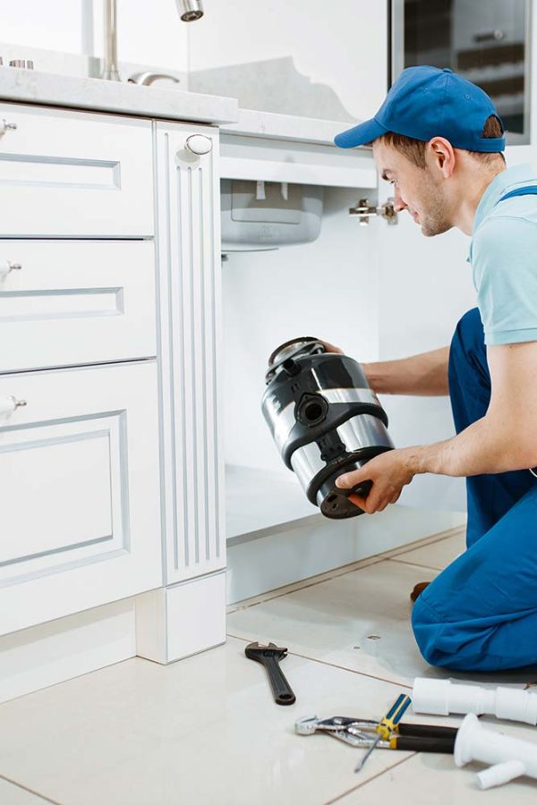 male-plumber-in-uniform-installing-disposer-resize.jpg