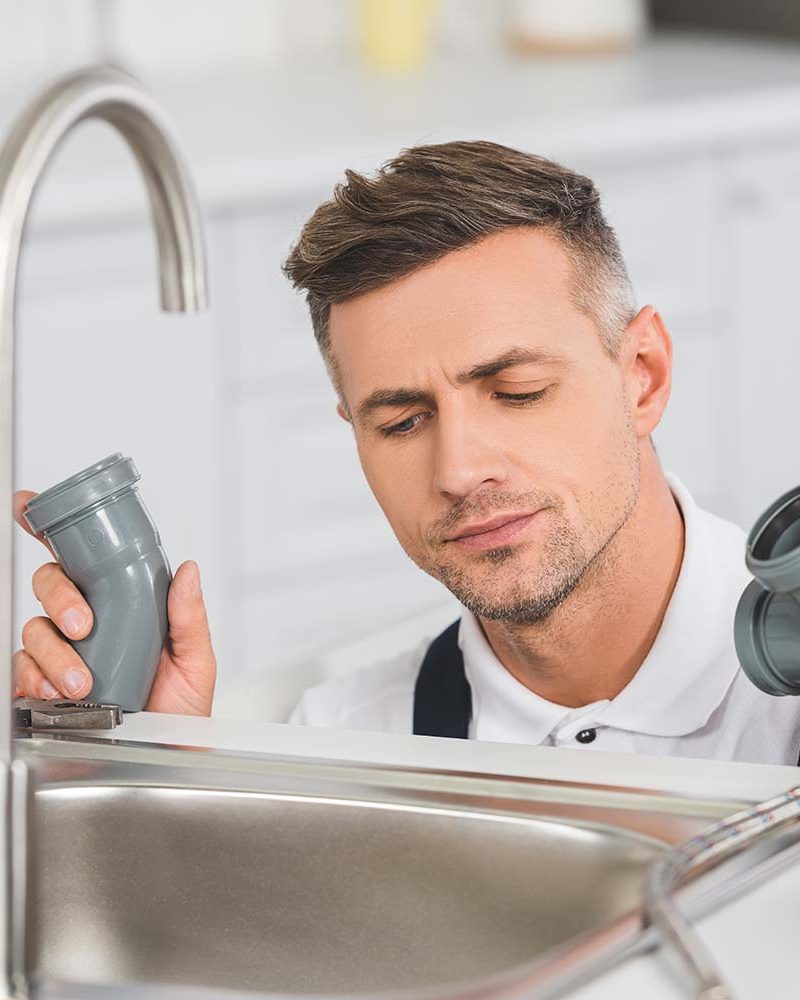 thoughtful-adult-repairman-holding-pipes-and-tools-resize.jpg